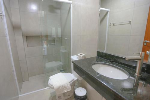 a bathroom with a sink and a shower and a toilet at Vila Nóbrega Residencial in Foz do Iguaçu