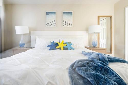 a white bed with blue and yellow stars on it at Premium Villa - Ocean View - SEASCAPE - Heated Pools - Relaxing Fireplace - Ground Level in Aptos