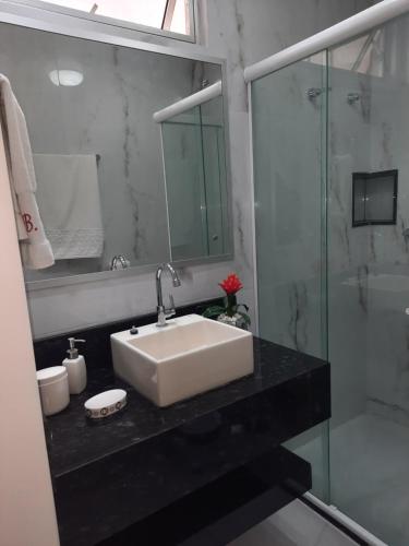 W łazience znajduje się umywalka i przeszklony prysznic. w obiekcie Bahia Flat 301 w mieście Salvador