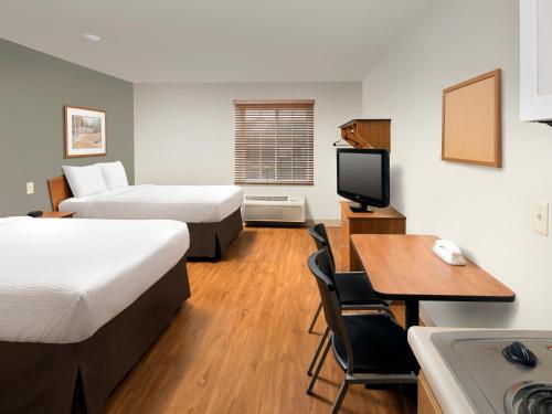 a hotel room with two beds and a desk and a kitchen at Extended Stay America Select Suites - Cleveland - Mentor in Mentor