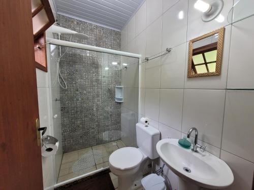 a bathroom with a toilet and a sink and a shower at Chalé Paraíso Fazendinha Cachoeira Pet Friendly in Lumiar