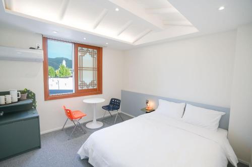 1 dormitorio con cama blanca y ventana en HotelArrive Jeonju Sihwayeonpung, en Jeonju