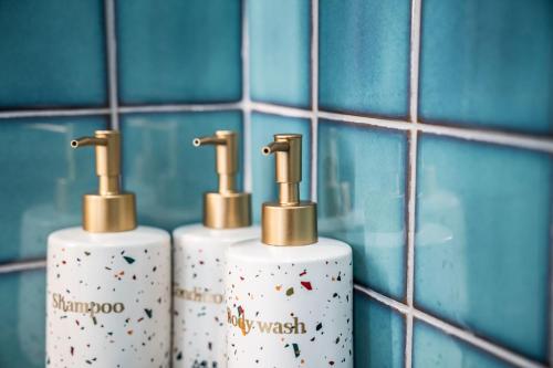 three rolls ofodorizers in a bathroom with blue tiles at HotelArrive Jeonju Sihwayeonpung in Jeonju