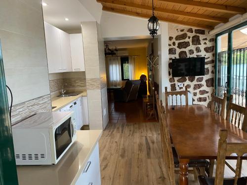 a kitchen and living room with a microwave and a table at Villa Emilia in Ruidera