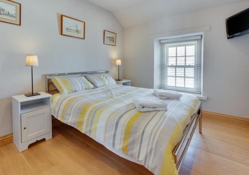 a bedroom with a bed with two towels on it at Awelon y Mor in Aberaeron