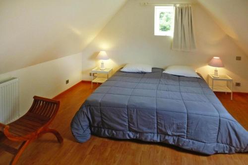 ein Schlafzimmer mit einem Bett, einem Stuhl und einem Fenster in der Unterkunft Holiday Home Plouégat-Guérand - BRE05042-F in Plouégat-Guérand
