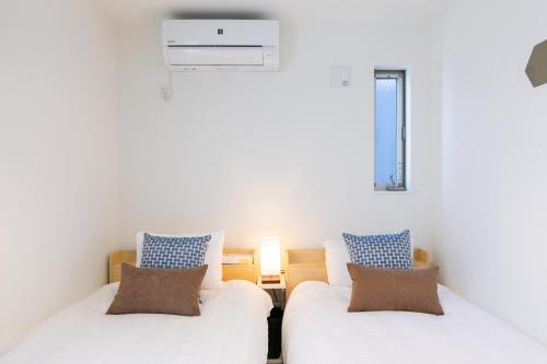 two white beds in a room with a window at SHIBUYA TOKYO in Tokyo