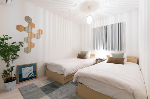 two beds in a room with white walls at SHIBUYA TOKYO in Tokyo