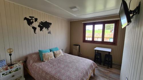 1 dormitorio con 1 cama con mapa en la pared en Wanderlust Monoambiente Ushuaia en Ushuaia