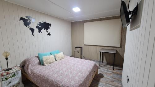 1 dormitorio con cama y pantalla de proyección en Wanderlust Monoambiente Ushuaia en Ushuaia