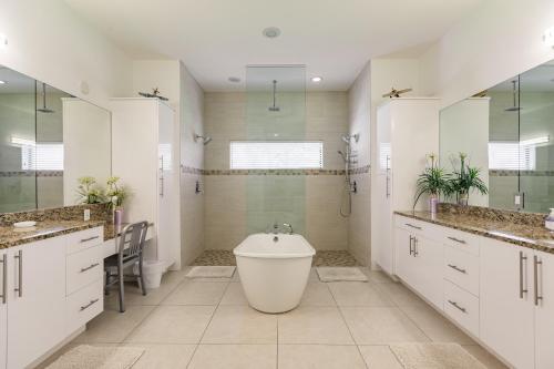 Un baño blanco con bañera y lavabo. en Villa Aviator, en Cabo Coral