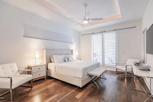 Un dormitorio blanco con una cama y un escritorio. en Villa Aviator, en Cabo Coral