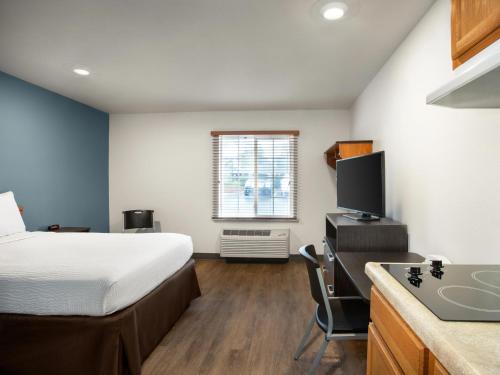 Un dormitorio con una cama y una cocina con fregadero. en Extended Stay America Select Suites - Charleston - Ashley Phosphate Rd, en Hanahan