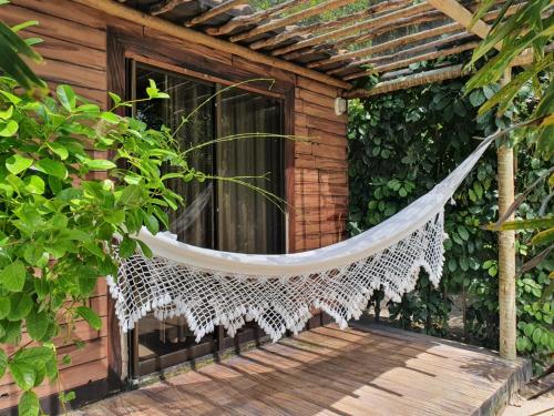 a hammock on a porch of a house at Chalés Refúgio Fortim in Fortim