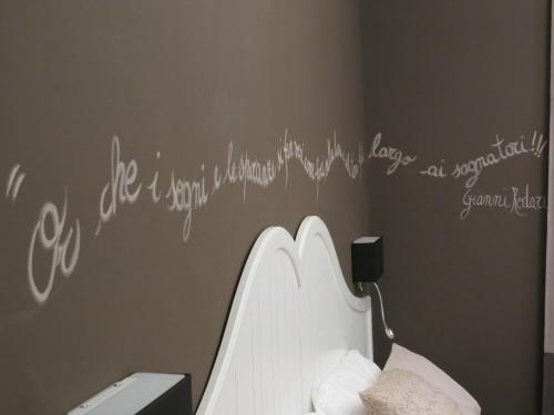 a bedroom with a white writing on the wall at Hotel Ristorante Eurossola in Domodossola
