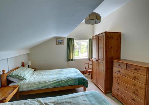 a bedroom with two beds and a dresser and a window at Black Patch in Norton