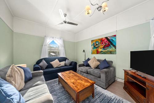 a living room with two couches and a flat screen tv at Giants Table and Cottages in Maydena
