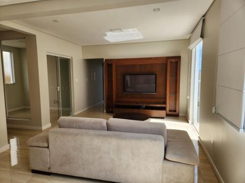 uma sala de estar com um sofá e uma televisão em Apto inteiro de luxo em Diamantina em Diamantina