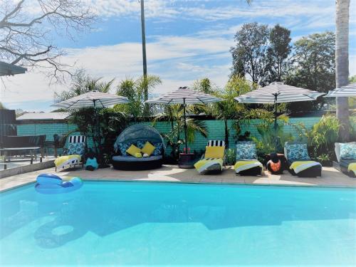 ein Pool mit Stühlen und Sonnenschirmen daneben in der Unterkunft Mulwala Resort in Mulwala