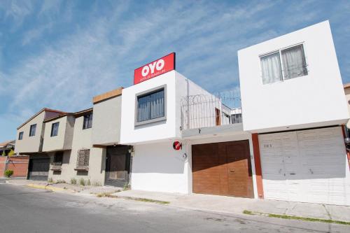 a white building with a oop sign on top of it at Hotel de Guadalupe in Puebla