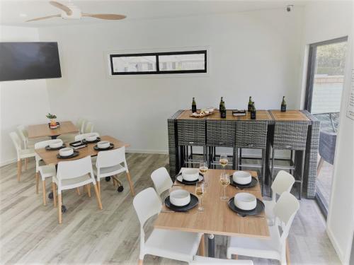 a dining room with wooden tables and white chairs at Mulwala Resort in Mulwala