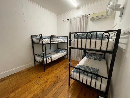 two bunk beds in a room with wooden floors at Gonow Family Backpackers Hostel in Brisbane