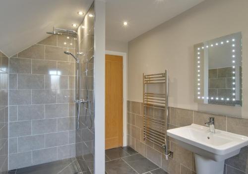 uma casa de banho com um lavatório e um chuveiro em Bwthyn Ednyfed em Criccieth