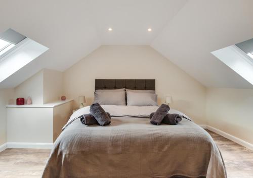 um quarto com uma cama grande num sótão em Bwthyn Clyd em Llanddyfnan