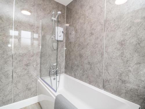 a bathroom with a shower with a bath tub at 2 Lane End Cottages in Hull