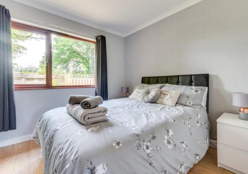 1 dormitorio con 1 cama con toallas en Cheries Place, en Amroth