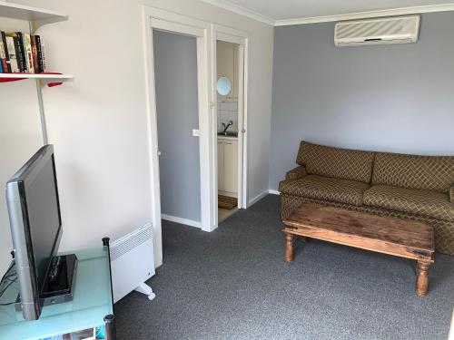 a living room with a couch and a tv at Portarlington Holiday Apartment in Portarlington