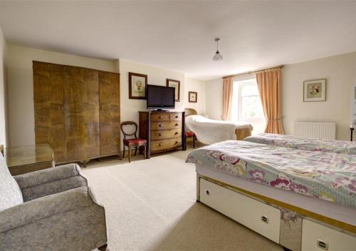 ペンブロークにあるClynderwen Houseのベッドルーム(ベッド1台、ソファ、テレビ付)