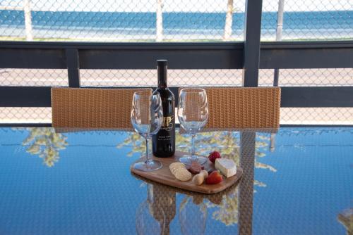 a table with a bottle of wine and two glasses at Ceduna Foreshore Caravan Park in Ceduna