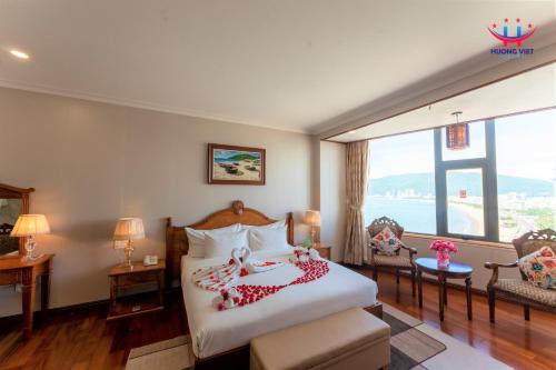 a bedroom with a bed and a large window at Huong Viet Hotel Quy Nhon - Beachfront in Quy Nhon
