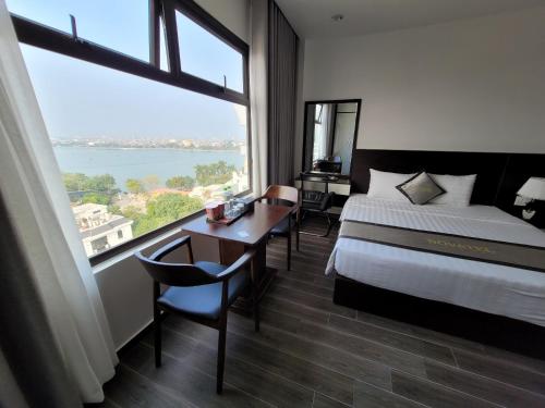 pokój hotelowy z łóżkiem i dużym oknem w obiekcie Novatel Hotel & Apartment w Hajfong