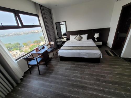 a hotel room with a bed and large windows at The Nova Hotel & Apartment in Hai Phong