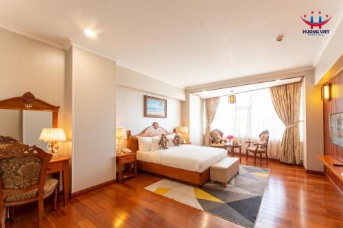 Huong Viet Hotel Quy Nhon - Beachfront في كوي نون: فندق غرفه بسرير ومكتب وغرفة