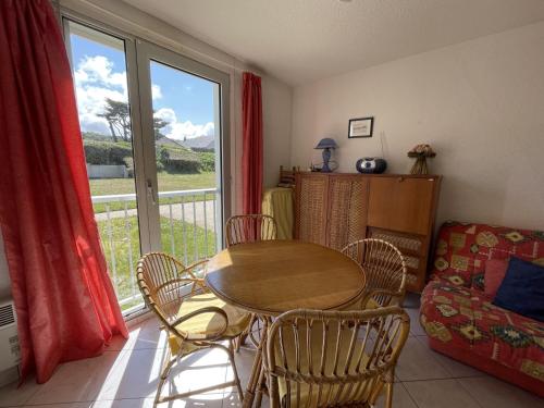 een eetkamer met een tafel en stoelen en een raam bij Appartement Jullouville, 1 pièce, 2 personnes - FR-1-361-10 in Jullouville-les-Pins