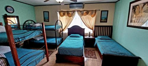 a room with three bunk beds and a window at Villa Alta Bed&Breakfast in Barranca