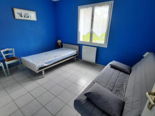 a blue room with a bed and a window at Maison de plain-pied avec jardin clôturé, proche Thermes St Roch - 3 chambres, WiFi, cuisine équipée - FR-1-541-46 in La Roche-Posay