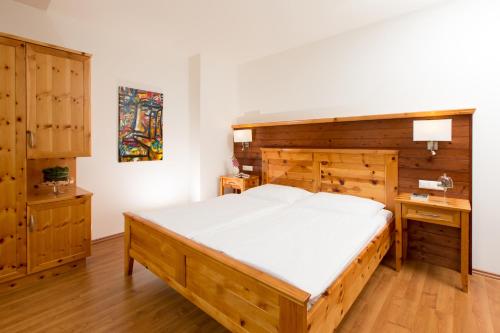 1 dormitorio con cama de madera y escritorio en Komfort Appartements Zirbenland - adults only - no dogs, en Weißkirchen in Steiermark