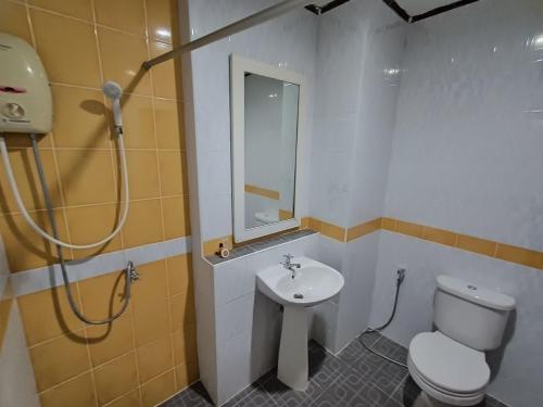 La salle de bains est pourvue de toilettes, d'un lavabo et d'une douche. dans l'établissement Rimtarn Hotel Pakchong, à Pak Chong