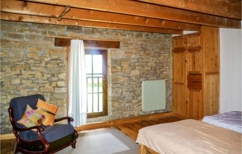 a bedroom with a stone wall and a chair at Beautiful Home In Loisia With Wifi in Loisia