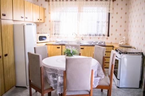 a kitchen with a table and chairs and a refrigerator at Casa Di Mattoni in Bento Gonçalves