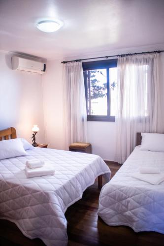 a bedroom with two beds and a window at Casa Di Mattoni in Bento Gonçalves