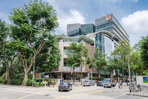 uma movimentada rua da cidade com carros estacionados em frente a um edifício em Tai Hoe Hotel em Singapura