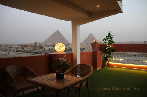 a table and chairs on a balcony with the pyramids at Grand Pyramids Inn in Cairo