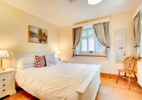 a bedroom with a large white bed and two windows at The Lodge in Pwllheli