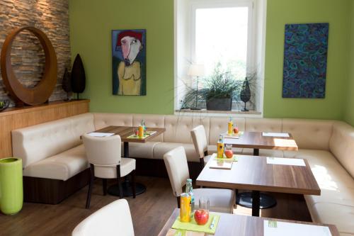 a restaurant with tables and chairs and a couch at Komfort Appartements Zirbenland - adults only - no dogs in Weißkirchen in Steiermark