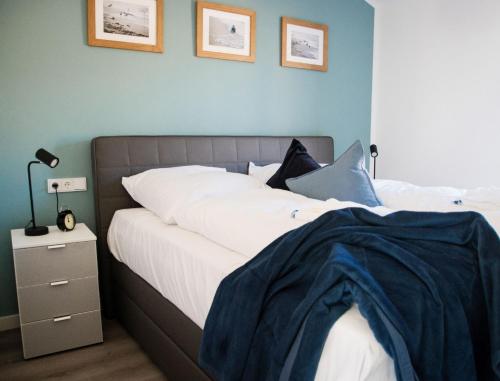 a bedroom with two beds and a blue wall at Ferienhaus "Q" - Wohnung 3 in Zingst